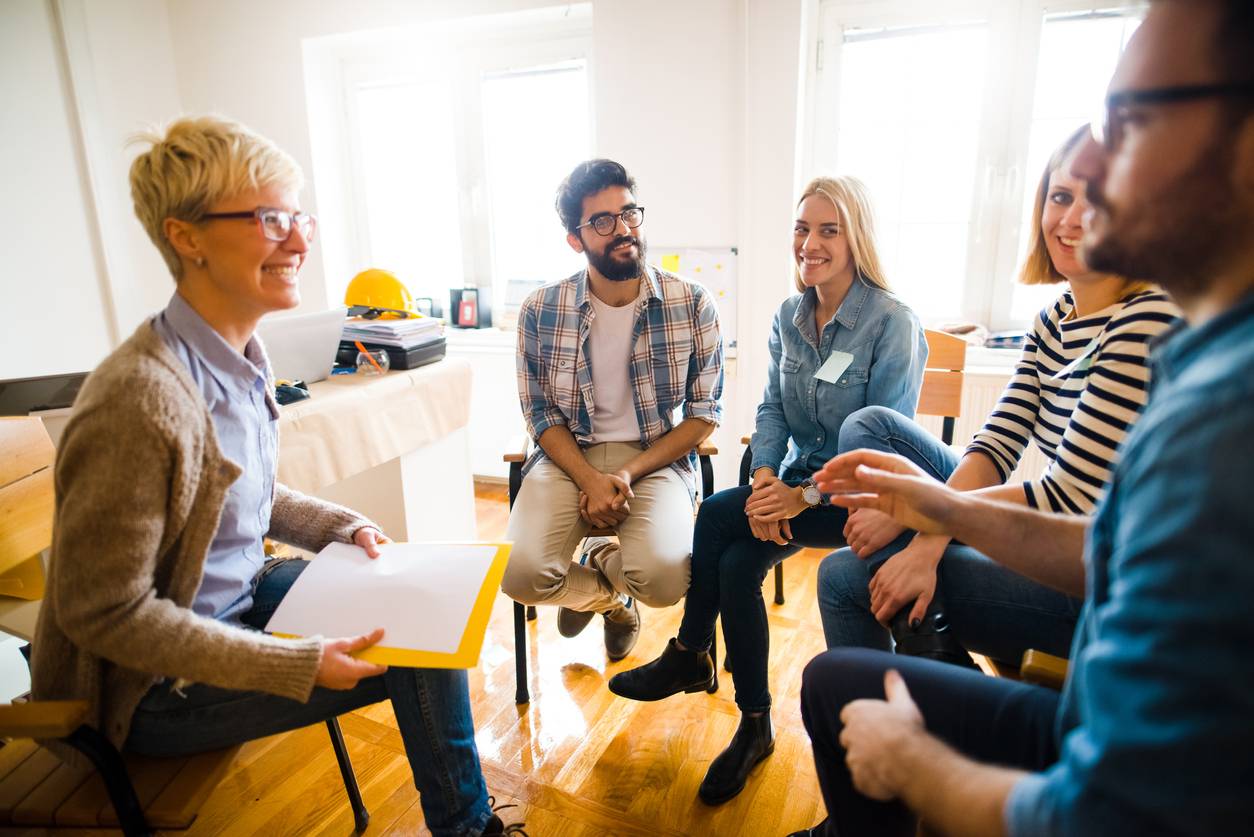 Employee engagement - group of people sitting in a circle and engaging with one another