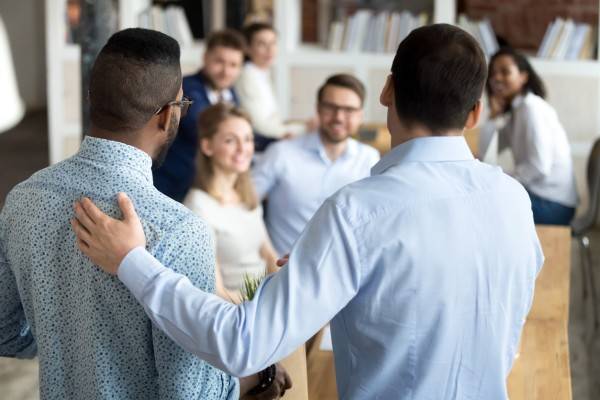 Employee onboarding - diverse workplace. New employee having first working day in company standing in front of colleagues, executive manager employer introducing welcoming newcomer to workmates. Human resources employment concept